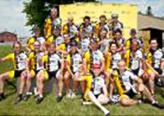 Un groupe de cyclistes du Tour Charles-Bruneau saluent de la main