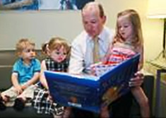 Un pre fait la lecture  ses trois enfants 